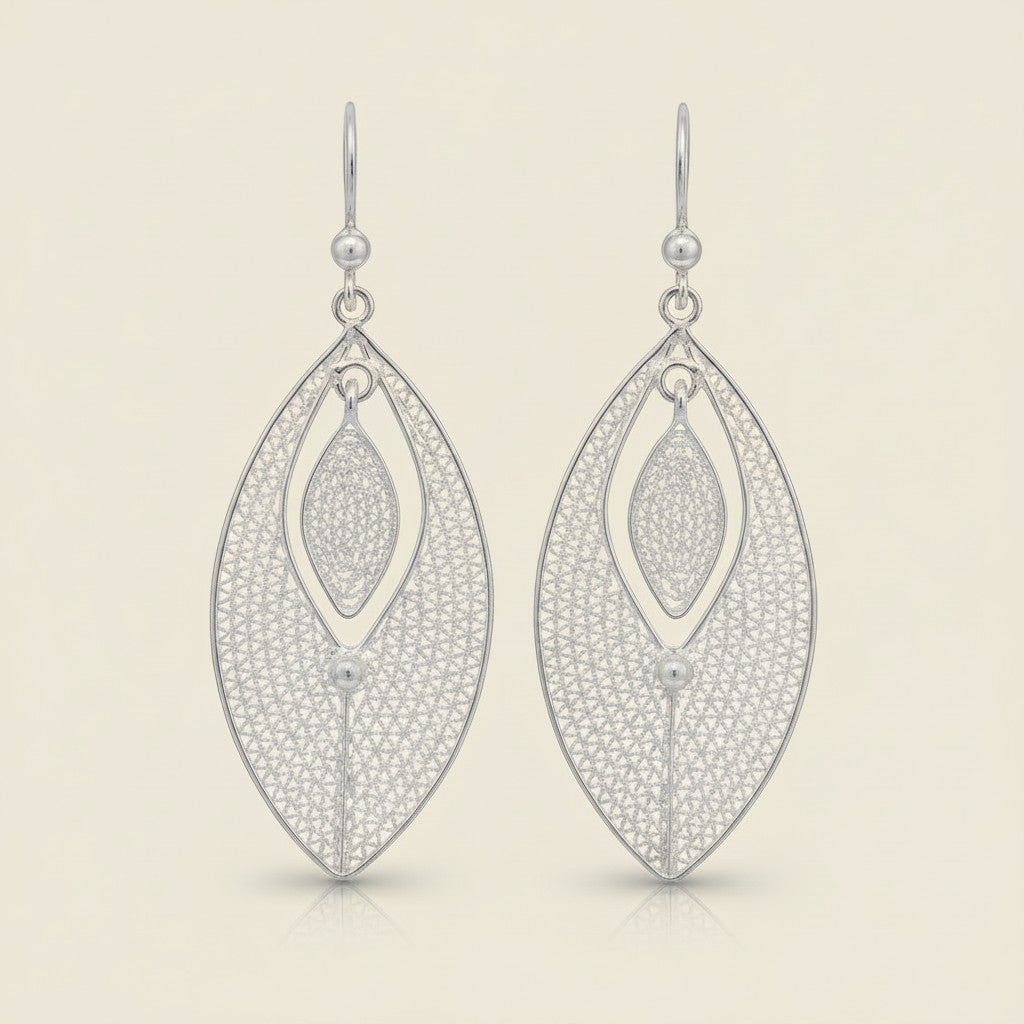 Tashra silver filigree leaf drop earrings with a delicate, intricate pattern and a modern, oval shape.
